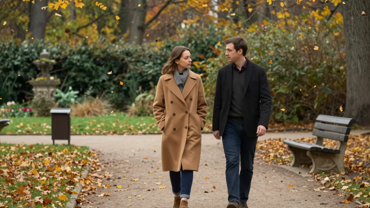 A man and woman walk together in Tiergarten Park during autumn, golden leaves falling around them.